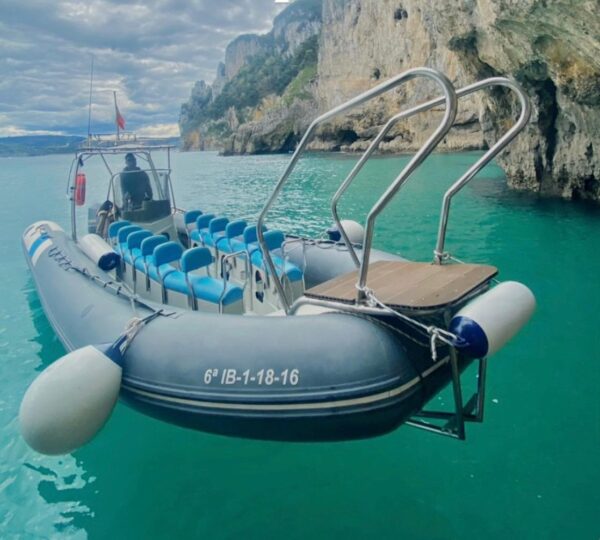 Embarcación de Taxi Express Faro preparada para excursiones en barco al Faro del Caballo desde Santoña, con asientos para pasajeros junto a acantilados y aguas turquesas.